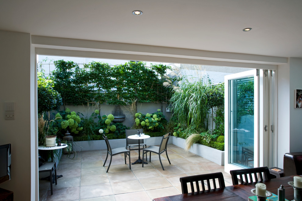 На фото: маленький двор на внутреннем дворе в классическом стиле с фонтаном и покрытием из каменной брусчатки для на участке и в саду с