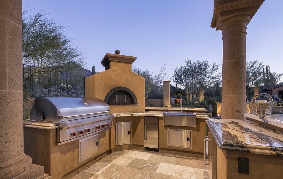 Geräumiger Mediterraner Patio hinter dem Haus mit Feuerstelle, Natursteinplatten und Gazebo in Phoenix