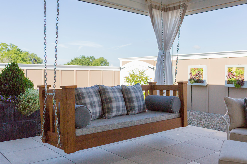 Cette photo montre une terrasse arrière chic de taille moyenne avec une cuisine d'été, des pavés en béton et une extension de toiture.
