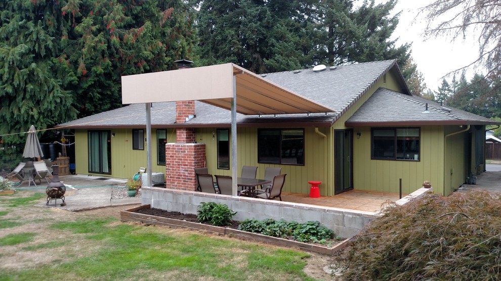 Inspiration for a mid-sized timeless backyard patio remodel in Portland with an awning and a fire pit