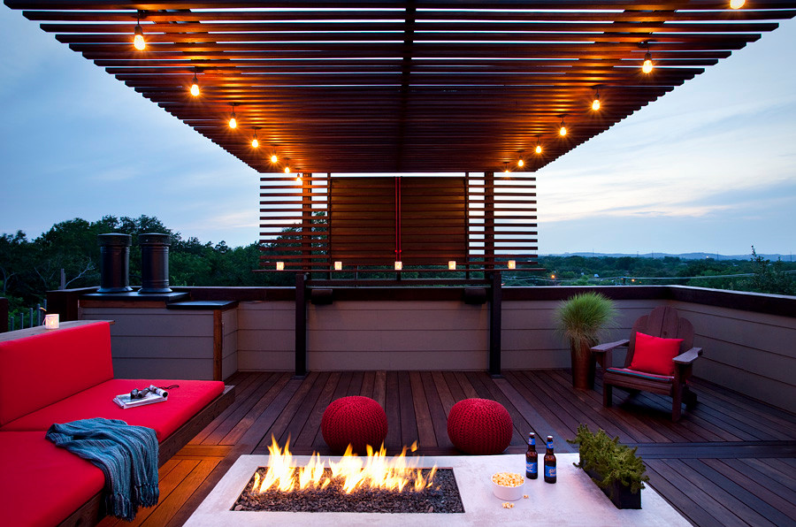 Inspiration for a mid-sized modern patio fountain remodel in Austin with decking and a pergola