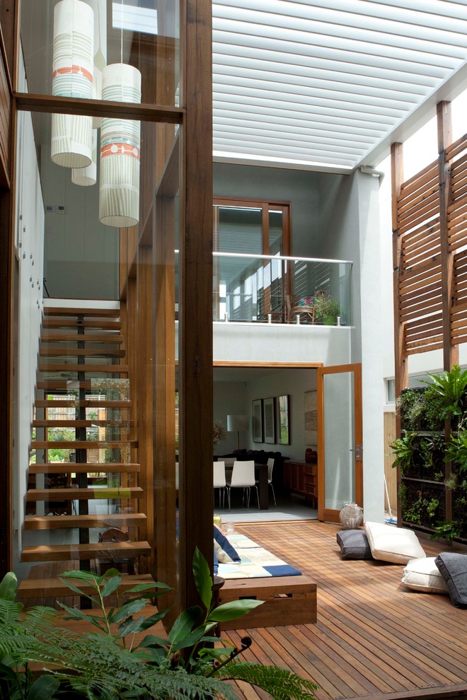 Cette photo montre une terrasse en bois tendance de taille moyenne avec une cour et une pergola.