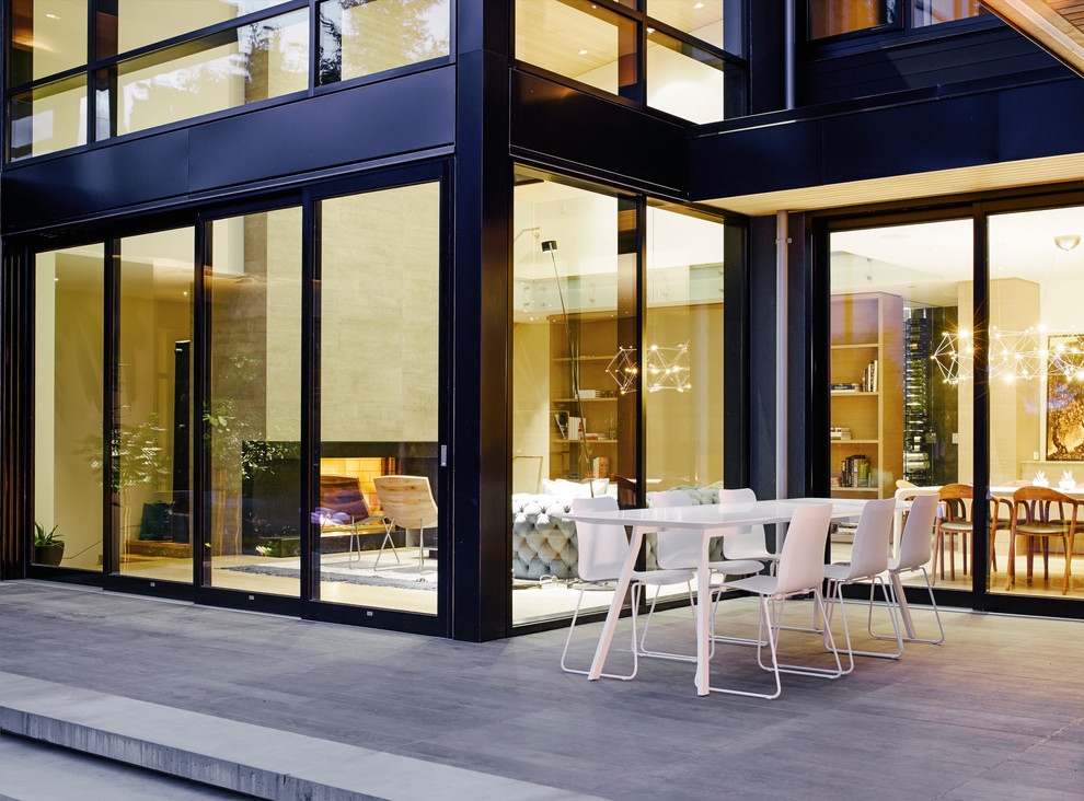 Стильный дизайн: большой двор на переднем дворе в современном стиле с покрытием из декоративного бетона - последний тренд