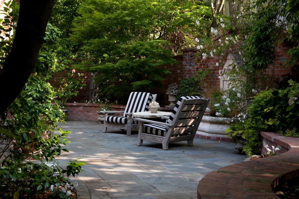 Foto de patio clásico de tamaño medio en patio con fuente y adoquines de piedra natural