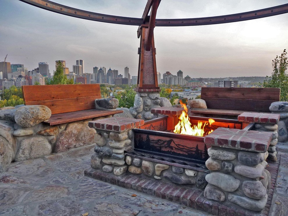 Patio - mid-sized craftsman backyard stone patio idea in Calgary with a fire pit and a pergola