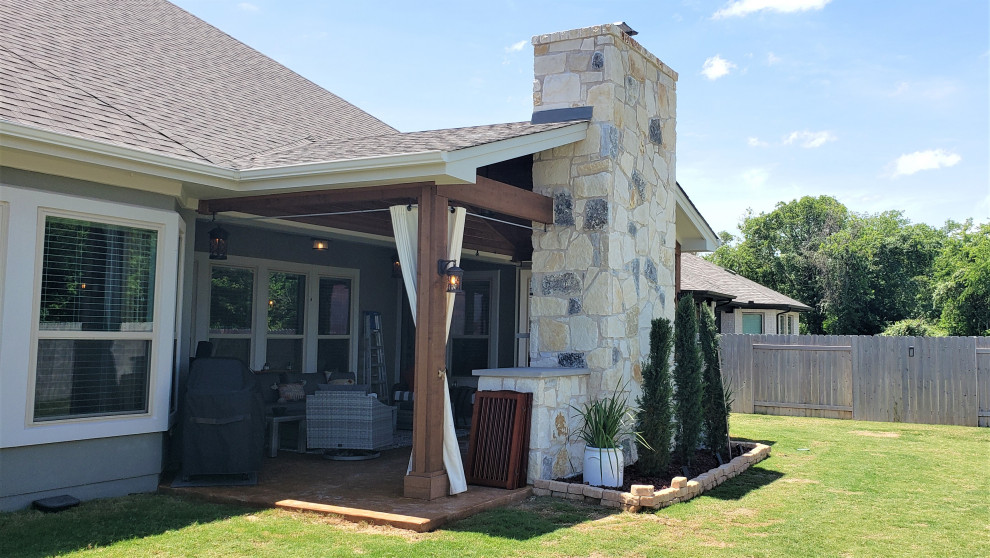 Überdachter Rustikaler Patio hinter dem Haus mit Kamin in Austin
