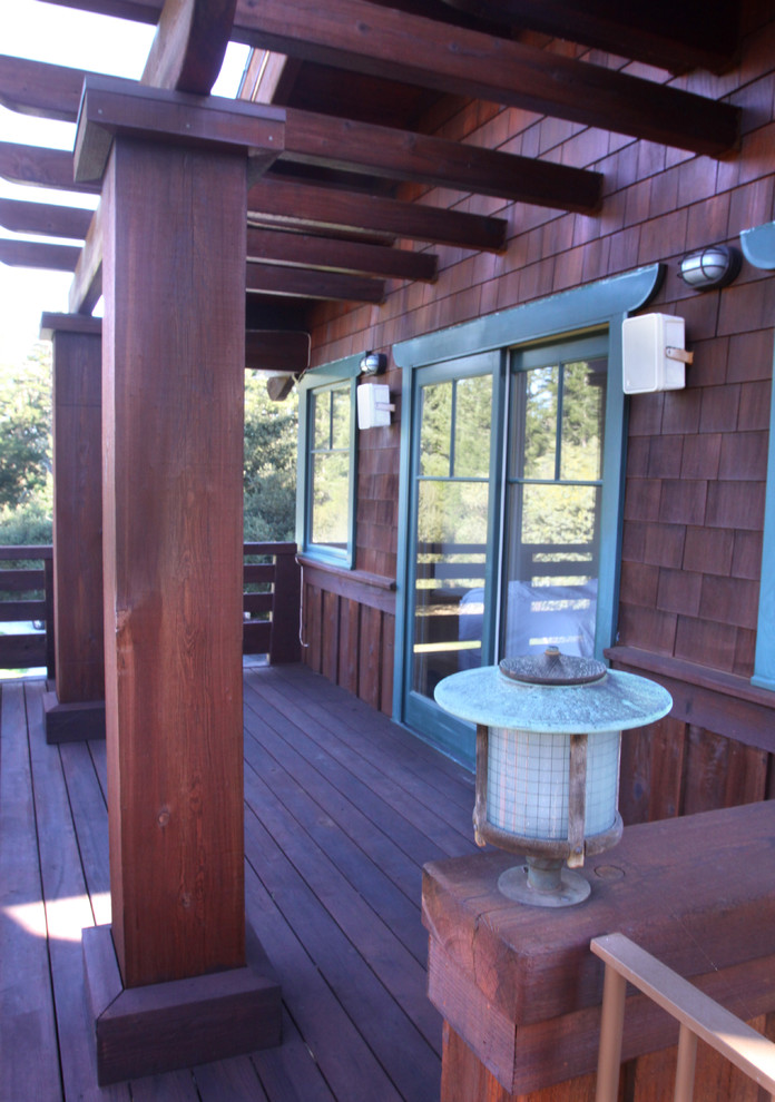 Cette image montre une grande terrasse arrière craftsman avec une extension de toiture.