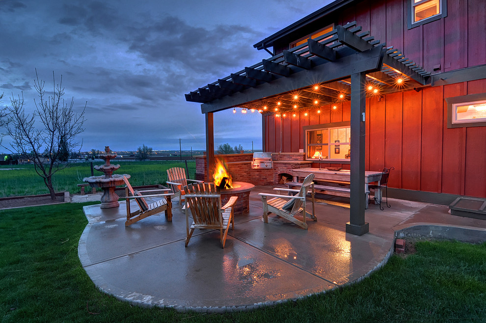 Country concrete paver patio photo in Denver with a fire pit and a pergola