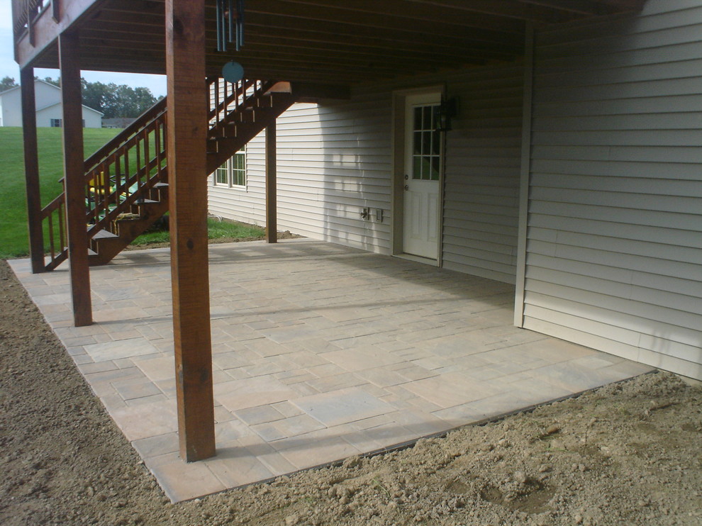 Idee per un grande patio o portico american style dietro casa con pavimentazioni in pietra naturale e nessuna copertura