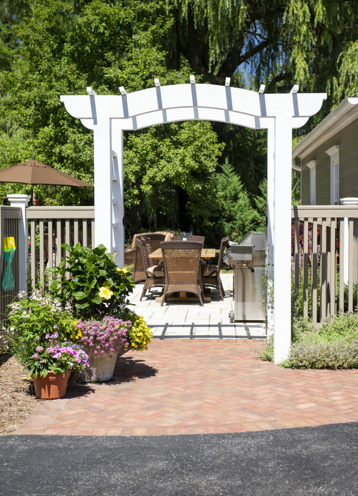 Esempio di un patio o portico rustico di medie dimensioni e in cortile con pavimentazioni in mattoni