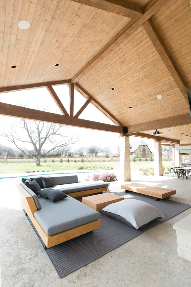 Foto di un grande patio o portico design dietro casa con cemento stampato e un tetto a sbalzo