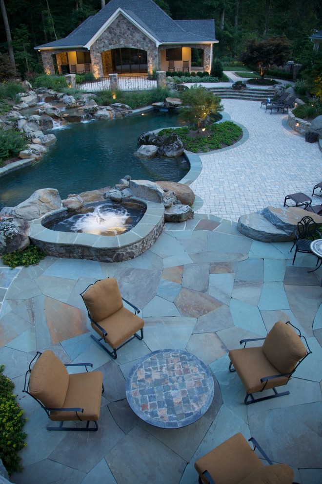 Modelo de patio clásico de tamaño medio en patio trasero con fuente y adoquines de piedra natural