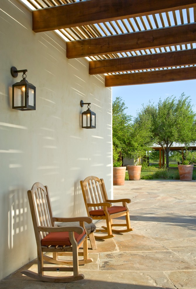 Patio - southwestern stone patio idea in Houston with a pergola