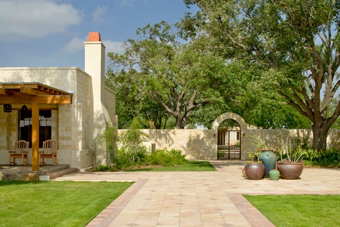 Cette image montre une terrasse sud-ouest américain avec une cour, des pavés en pierre naturelle et une extension de toiture.