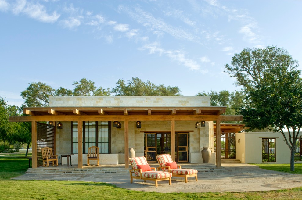 Esempio di un patio o portico american style in cortile con pavimentazioni in pietra naturale e un tetto a sbalzo