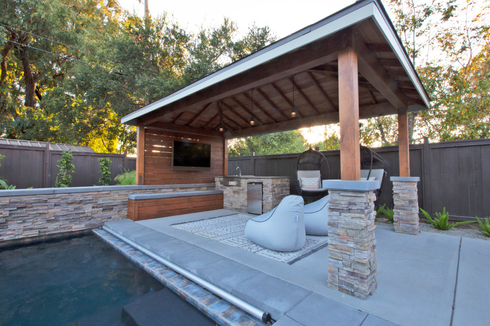 Diseño de patio moderno grande en patio trasero con fuente, losas de hormigón y cenador