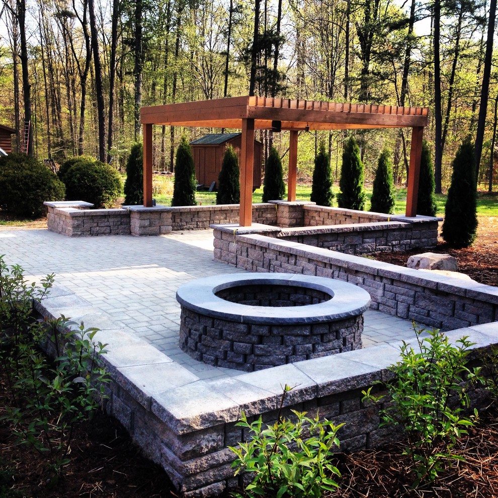 Large rustic back patio in Richmond with a fire feature, concrete paving and a pergola.