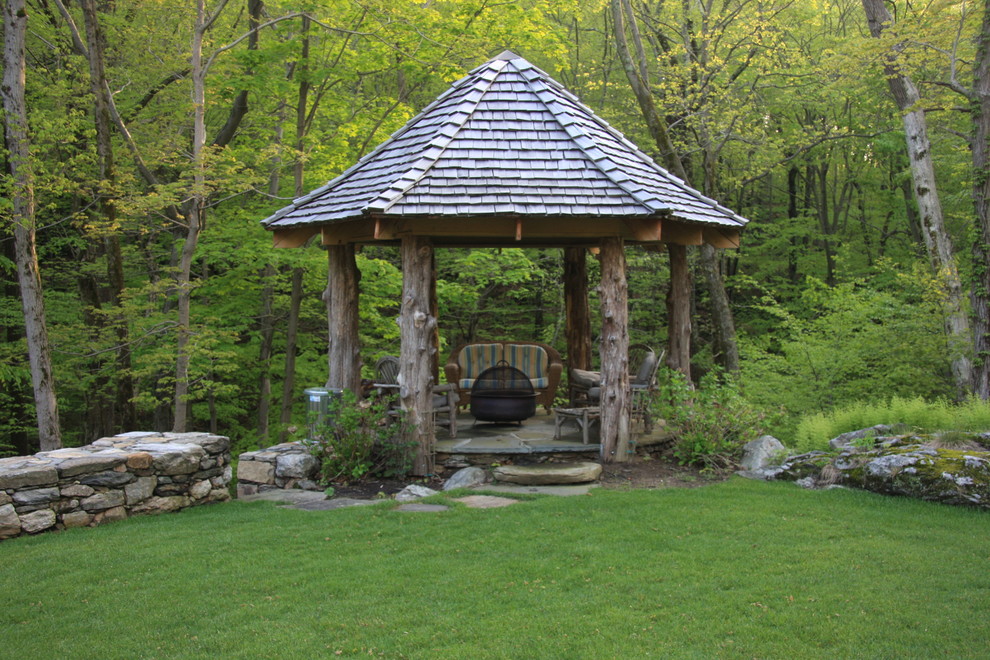 Exemple d'une terrasse montagne avec des pavés en pierre naturelle et un gazebo ou pavillon.