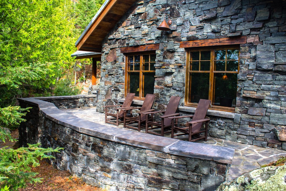 Mountain style stone patio photo in Minneapolis with no cover