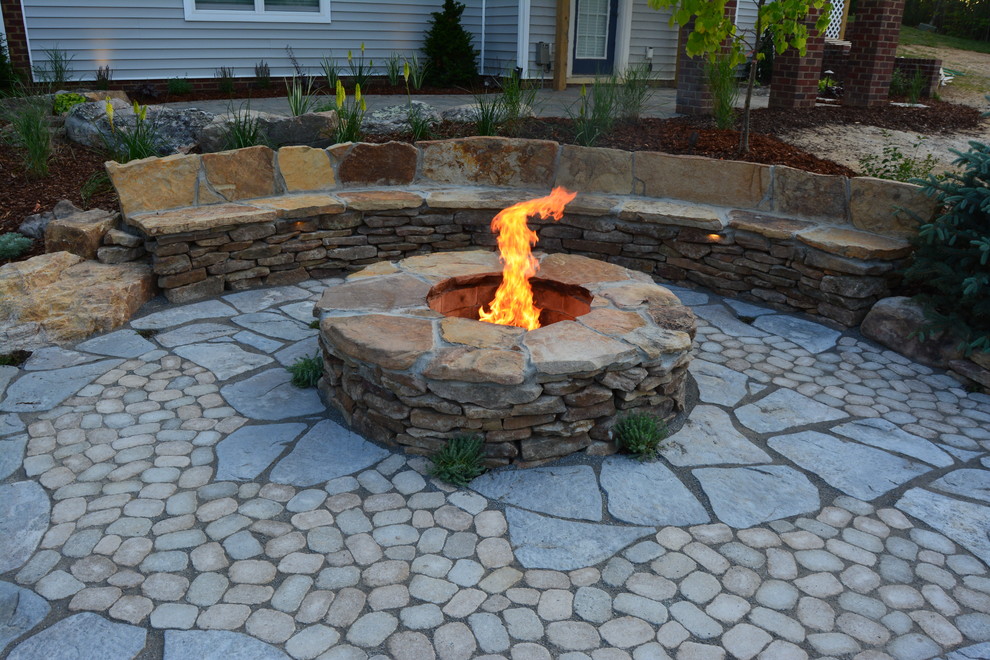Medium sized rustic back patio in Richmond with a fire feature and concrete paving.