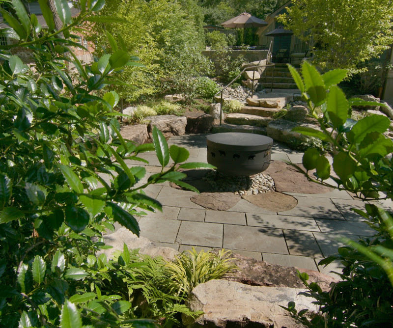 Cette image montre une terrasse arrière chalet de taille moyenne avec un foyer extérieur et des pavés en pierre naturelle.