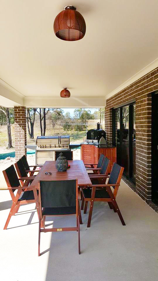 Cette photo montre une terrasse arrière tendance de taille moyenne avec une cuisine d'été, une dalle de béton et une extension de toiture.