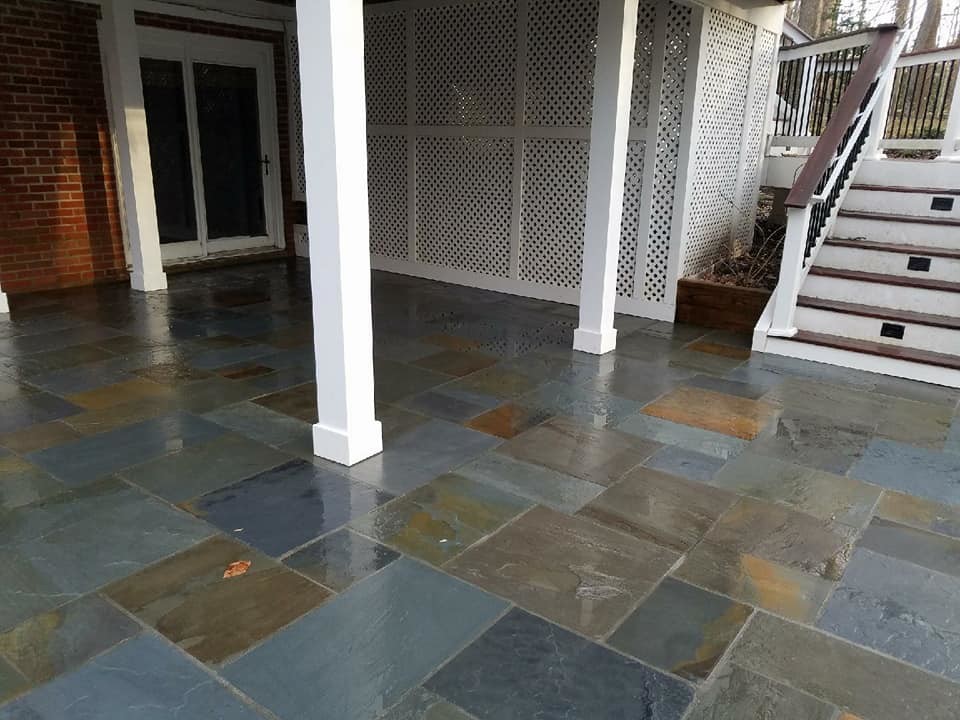 This is an example of an expansive classic back patio in Other with a water feature, natural stone paving and no cover.
