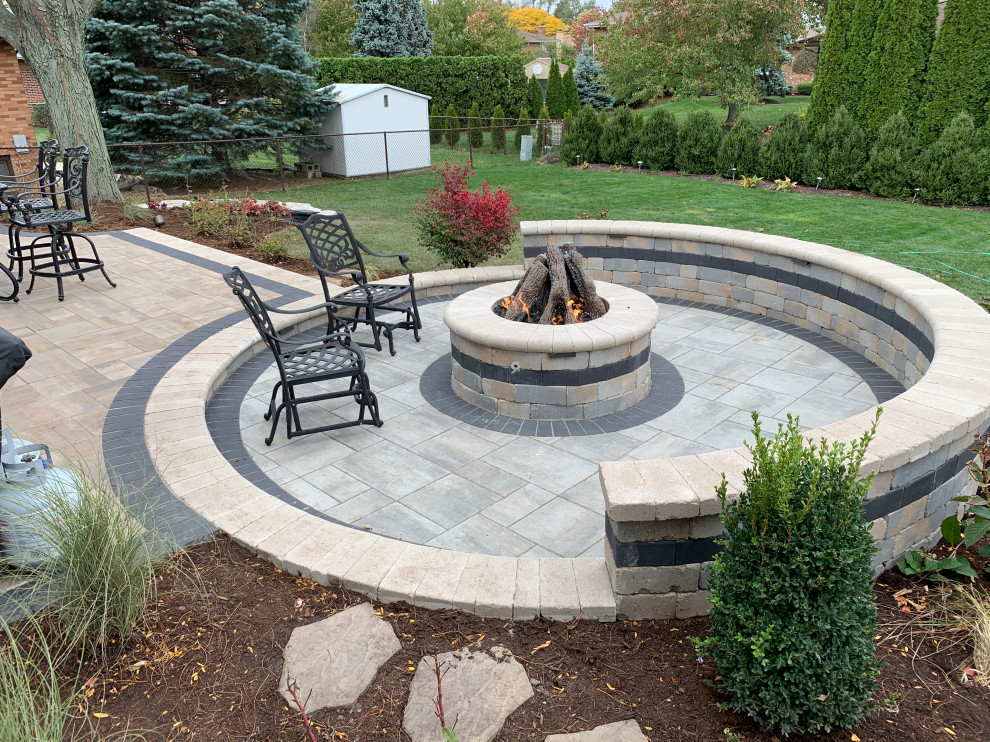 Inspiration for a large rustic back patio in Chicago with a fire feature, concrete paving and no cover.