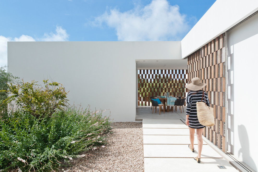 Стильный дизайн: двор на боковом дворе в средиземноморском стиле с покрытием из гравия без защиты от солнца - последний тренд