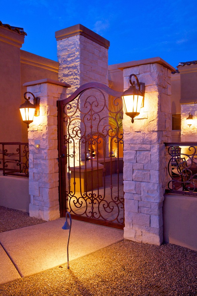 Design ideas for a large mediterranean front patio in Phoenix with natural stone paving and no cover.