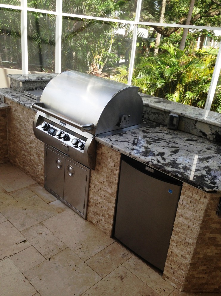 Medium sized contemporary back patio in Tampa with an outdoor kitchen and natural stone paving.