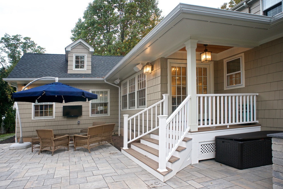Idee per un patio o portico costiero di medie dimensioni e dietro casa con un focolare e pavimentazioni in mattoni