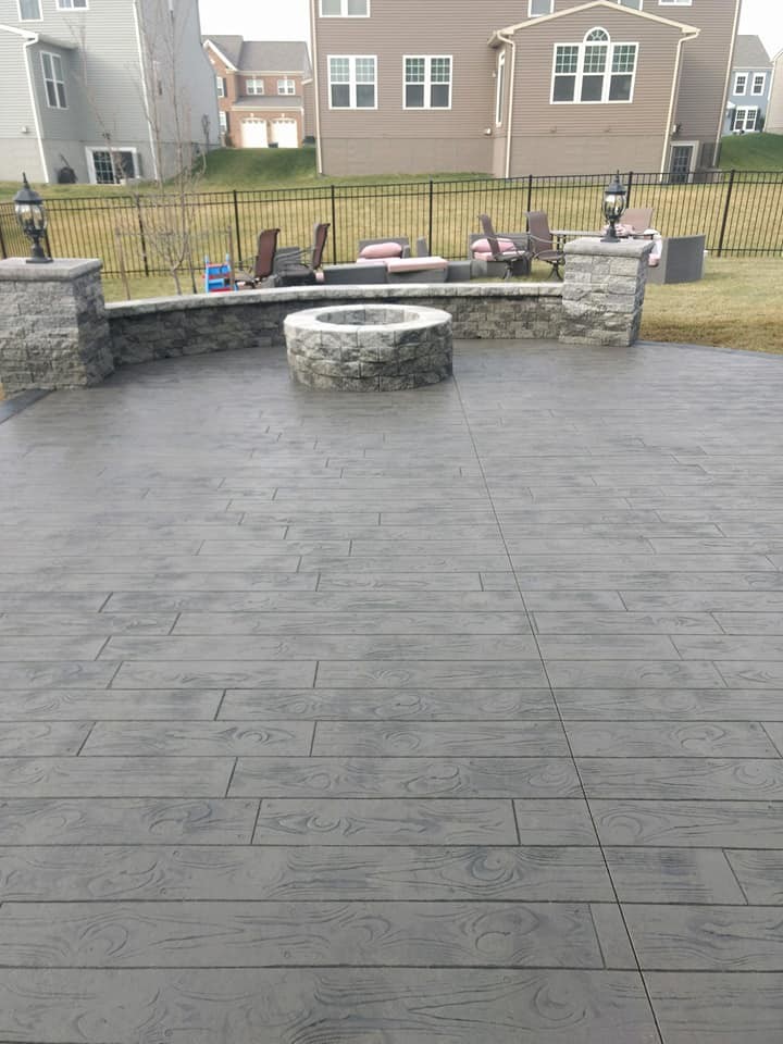 Large minimalist backyard stamped concrete patio photo in Other with a fire pit and no cover