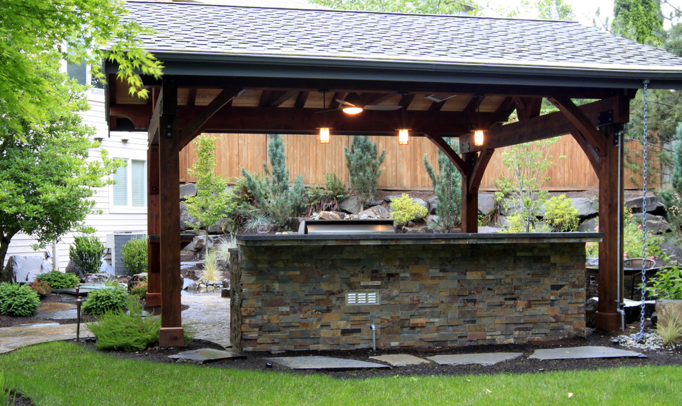 Imagen de patio tradicional grande en patio trasero con cocina exterior, adoquines de piedra natural y cenador