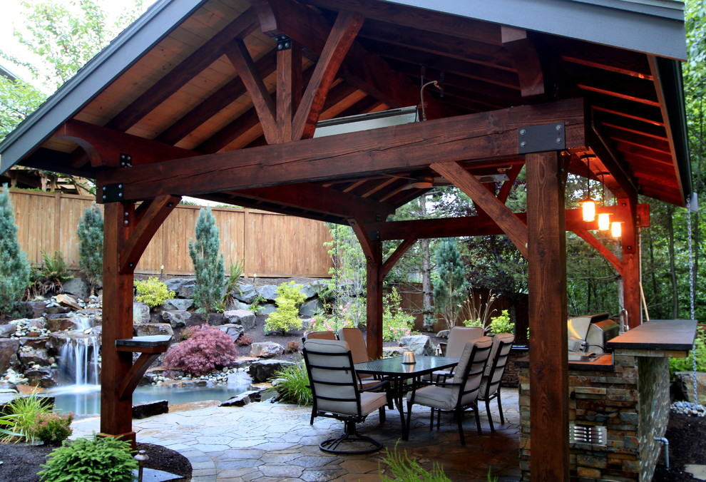 Patio kitchen - large traditional backyard stone patio kitchen idea in Seattle with a gazebo