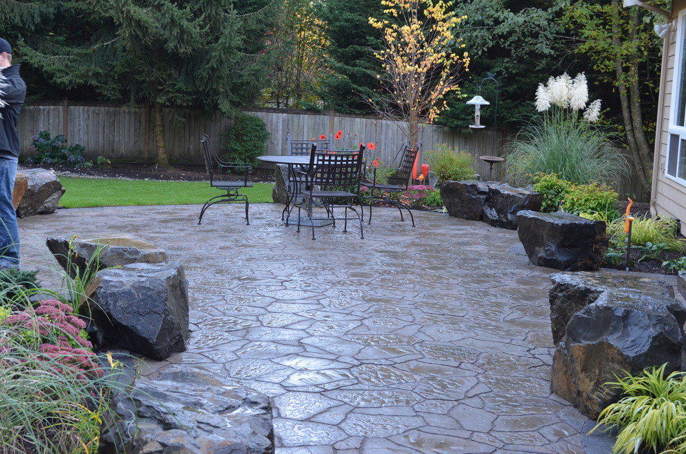 Diseño de patio tradicional grande en patio trasero con adoquines de piedra natural