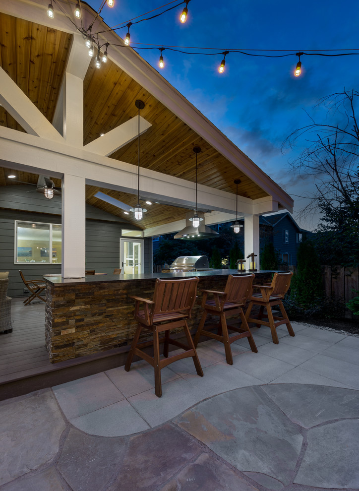 Diseño de patio clásico renovado grande sin cubierta en patio trasero con losas de hormigón y cocina exterior