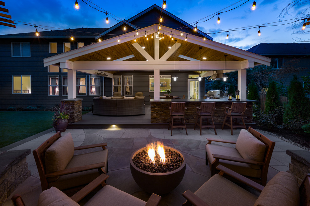 Photo of a large classic back patio in Seattle with a fire feature, concrete slabs and no cover.