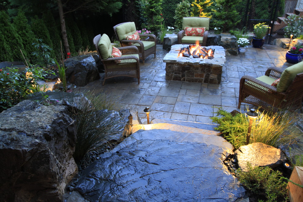 Modelo de patio tradicional de tamaño medio sin cubierta en patio trasero con brasero y adoquines de piedra natural
