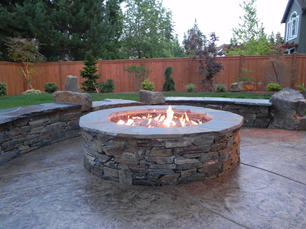 Patio - mid-sized contemporary backyard stamped concrete patio idea in Seattle with a fire pit