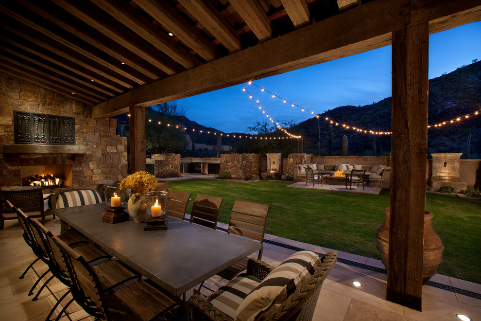 Example of a tuscan backyard patio design in Phoenix with a fire pit