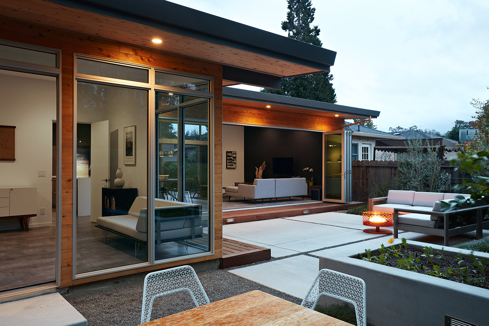 Пример оригинального дизайна: двор среднего размера на заднем дворе в стиле ретро с местом для костра, покрытием из бетонных плит и навесом