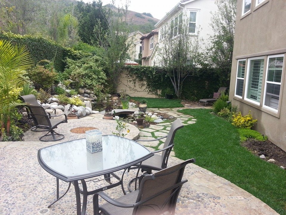 Exemple d'une terrasse arrière chic de taille moyenne avec une cuisine d'été, des pavés en pierre naturelle et aucune couverture.