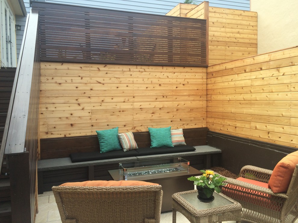 This is an example of a medium sized modern back patio in San Francisco with a fire feature, decking and no cover.