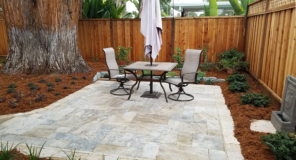 This is an example of a small retro back patio in Other with natural stone paving and no cover.