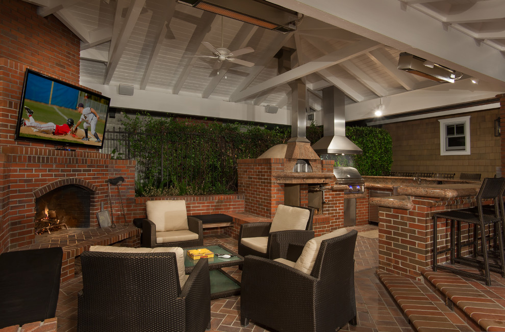 Example of a classic backyard brick patio kitchen design in San Diego with a roof extension