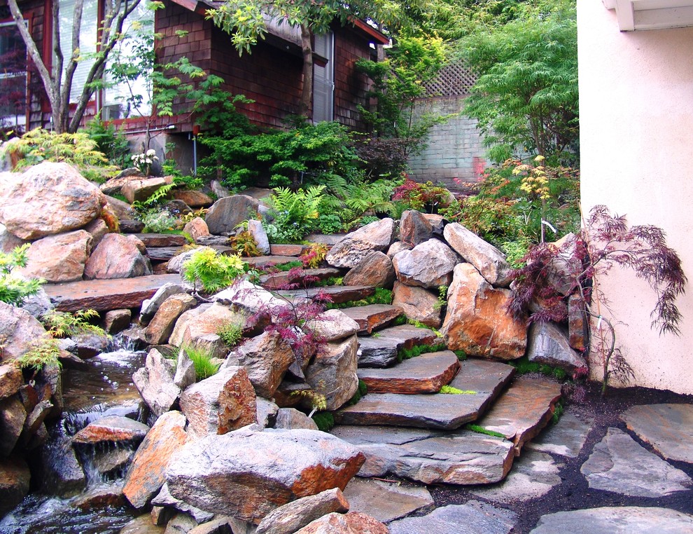 Immagine di un piccolo giardino etnico dietro casa con fontane e pavimentazioni in pietra naturale