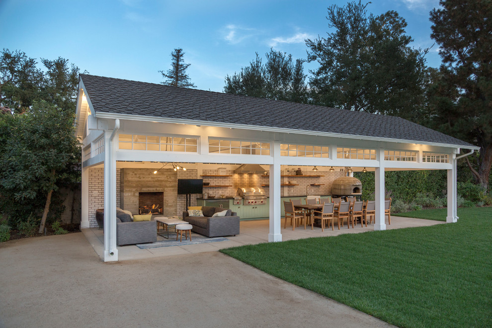 Example of a classic backyard concrete patio kitchen design in Los Angeles with a gazebo
