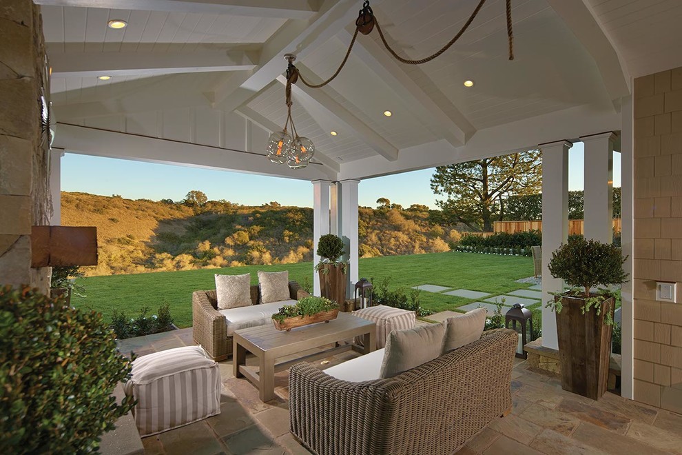 Inspiration for a coastal backyard tile patio remodel in Orange County with a roof extension