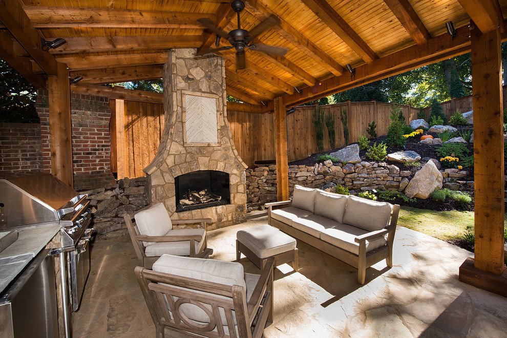 Photo of a large rustic back patio in Atlanta with a fire feature, natural stone paving and a gazebo.
